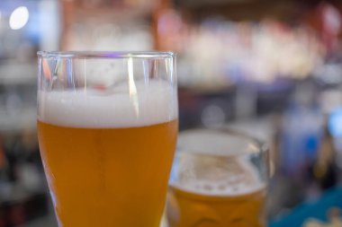 Bar arka planında arpa olan bir bardak light bira..