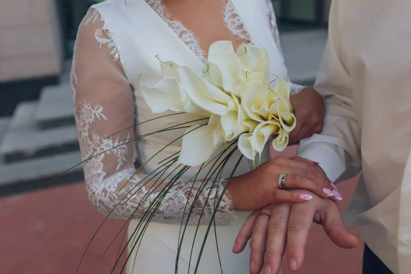 Mariée et marié tenant la main. Anneaux de mariage et détails de bouquet de mariées. — Photo