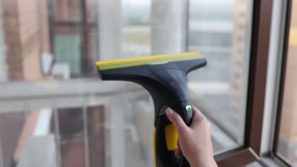 Bella giovane casalinga in abiti da lavoro lavare le finestre da strumenti professionali a casa. — Video Stock
