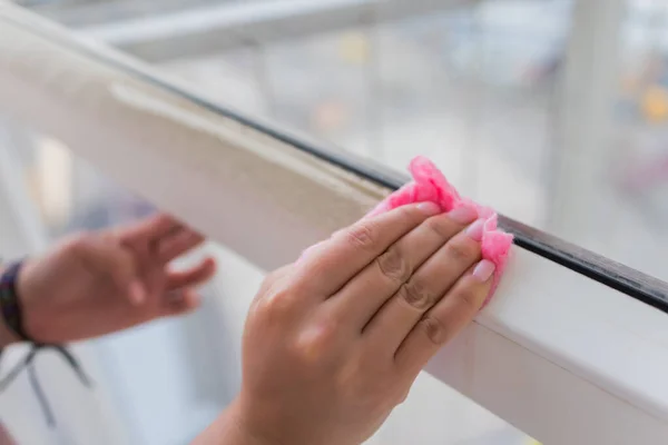 The woman washes a window in apartment.