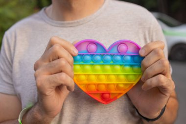 man using pop it fidget toy closeup.