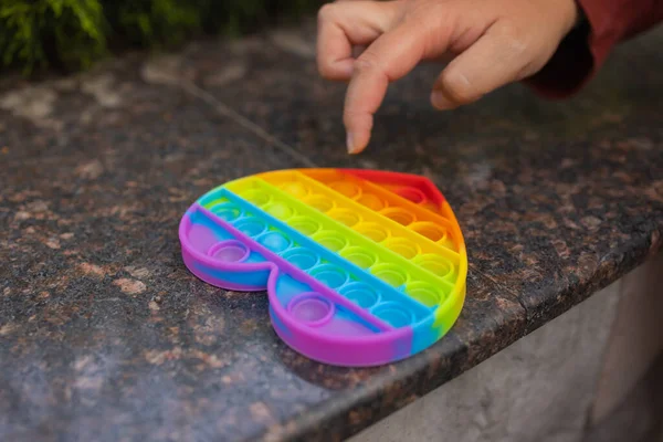 Woman using pop it fidget toy closeup.