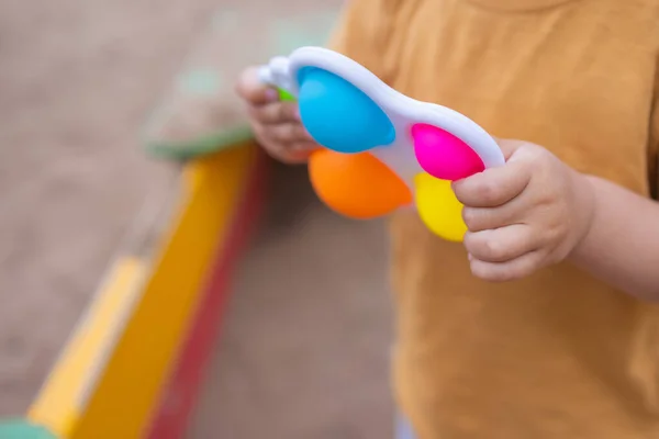 Colorful trendy antistress sensory toy fidget push pop it and simple dimple in kids hands, children share toys and playing together. — Fotografia de Stock