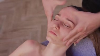 Kadın yüzüne masaj yapan masözlerin ellerini kapatın. Kadın zevkle gözlerini kapadı..