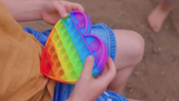 Πολύχρωμο αντιστρες αισθητηριακό παιχνίδι fidget push pop αυτό σε μικρά παιδιά χέρια. Antistress μοντέρνο ποπ παιχνίδι. Αισθητηριακό δαιμόνιο. Νέο μοντέρνο παιχνίδι σιλικόνης. — Αρχείο Βίντεο