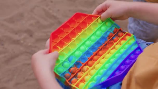 Kleurrijke antistress zintuiglijke speelgoed fidget duwen pop het in peuters handen. Antistress trendy pop het speelgoed. Regenboog zintuiglijke viool. Nieuw trendy siliconen speelgoed. — Stockvideo