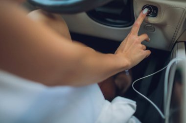 Çalıştırma anahtarı arabada olan bir kadın el.