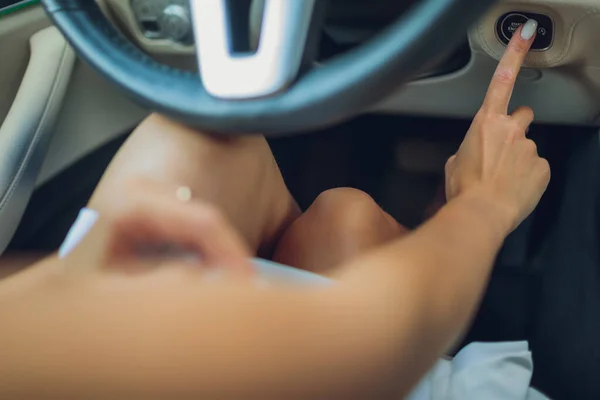 Женская рука с ключом запуска внутри автомобиля. — стоковое фото