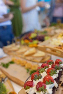 Güzel yaz çiçekleriyle süslenmiş abur cuburlarla dolu yemek masası. Yemek Masası Lezzetli Organik Yemekler Konsepti. Misafiri bekliyoruz..