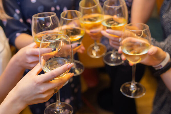 Clinking glasses with alcohol and toasting, party.