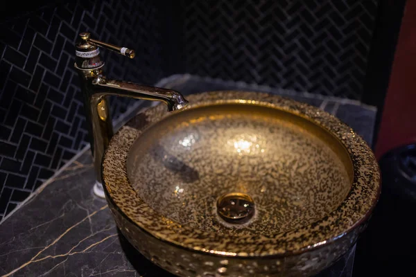 Красивый кран и золотой миксер на мраморной раковине в ванной комнате. Интерьер дорогого туалета с мраморной раковиной. — стоковое фото
