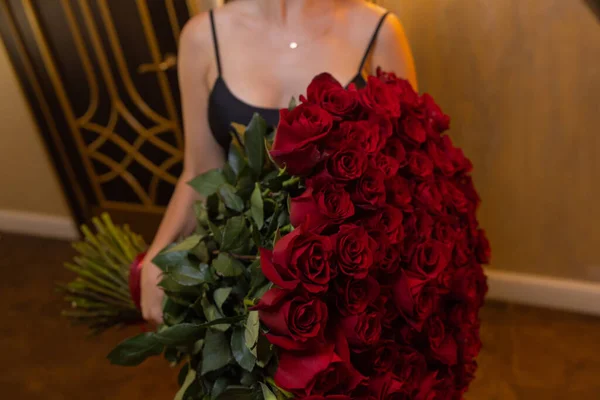 Mujer sostiene ramo de lujo de rosas rojas. — Foto de Stock