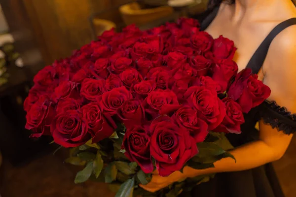 Kobieta posiada luksusowy bukiet czerwonych róż. — Zdjęcie stockowe