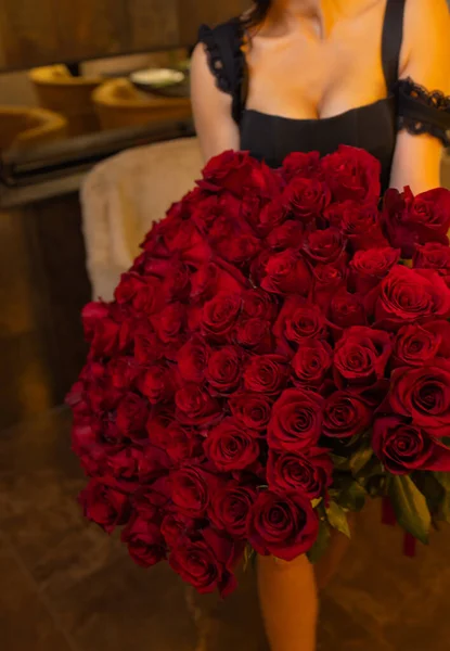 Kobieta posiada luksusowy bukiet czerwonych róż. — Zdjęcie stockowe