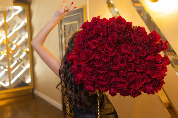 Mulher detém buquê de luxo de rosas vermelhas. — Fotografia de Stock