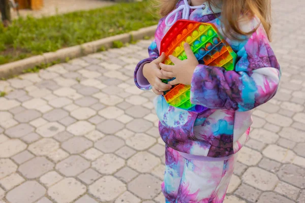 Pop-lo brinquedo fidget em mãos de menina. colorido antistress crianças brinquedo fidget. — Fotografia de Stock