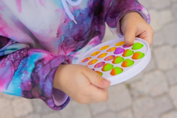 Pop-lo brinquedo fidget em mãos de menina. colorido antistress crianças brinquedo fidget. — Fotografia de Stock