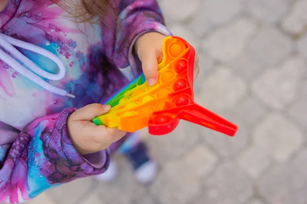 Pop-lo brinquedo fidget em mãos de menina. colorido antistress crianças brinquedo fidget. — Fotografia de Stock