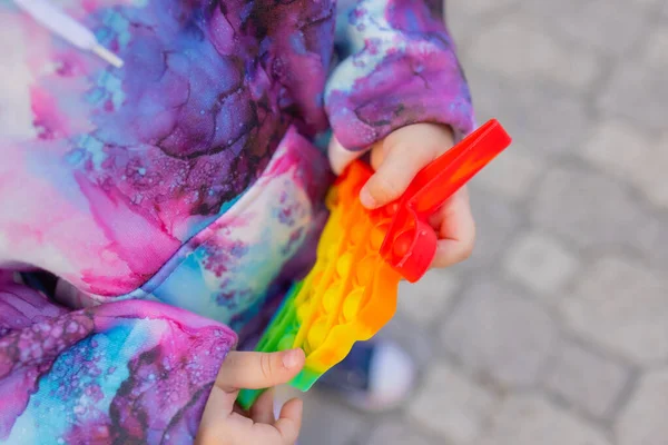 Pop-lo brinquedo fidget em mãos de menina. colorido antistress crianças brinquedo fidget. — Fotografia de Stock