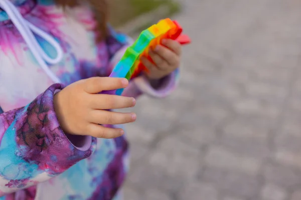 Pop it fidget juguete en manos de chica. Colorido antiestrés niños juguete fidget. — Foto de Stock