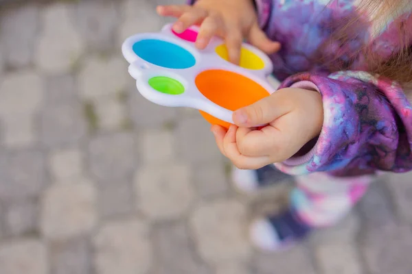 Pop-lo brinquedo fidget em mãos de menina. colorido antistress crianças brinquedo fidget. — Fotografia de Stock