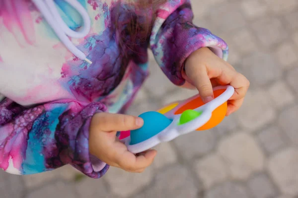 Pop-lo brinquedo fidget em mãos de menina. colorido antistress crianças brinquedo fidget. — Fotografia de Stock