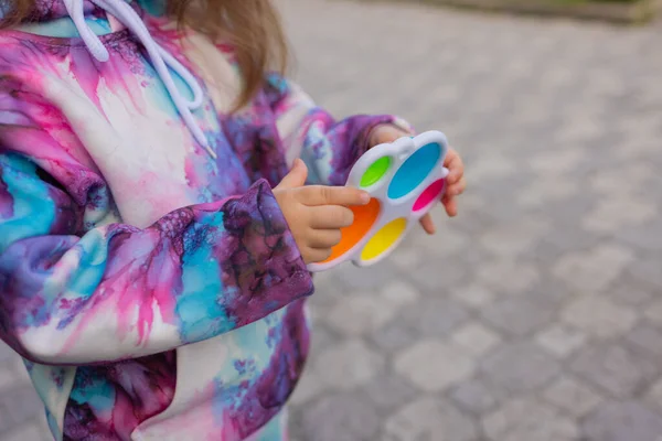 Pop it fidget jouet dans les mains des filles. Jouet anti-stress coloré pour enfants violon. — Photo