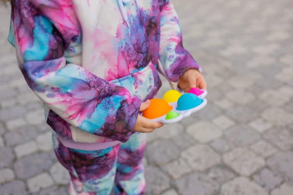 Pop it Fidget Toy in Mädchenhänden. Bunte Antistress-Kinder zappeln. — Stockfoto