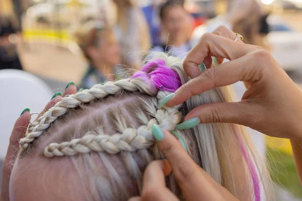 Жіночі руки плетуть косичку на голові брюнеток . — стокове фото