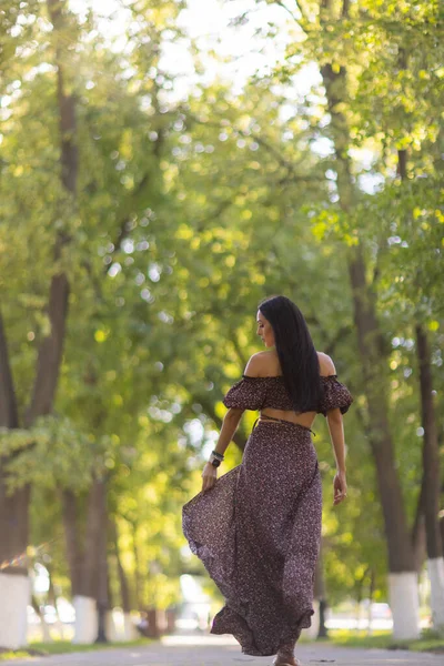 Bela jovem mulher em óculos no parque em um fundo de vegetação. — Fotografia de Stock