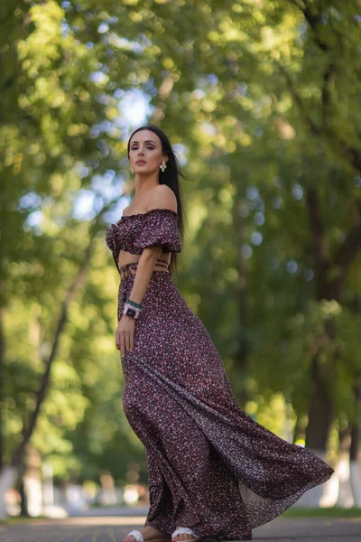 Bela jovem mulher em óculos no parque em um fundo de vegetação. — Fotografia de Stock