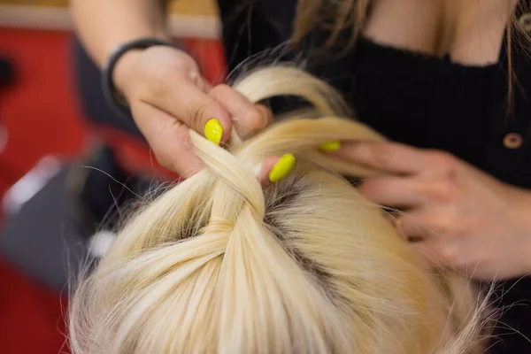 Жіночі руки плетуть косичку на голові брюнеток . — стокове фото