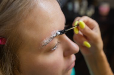 Güzellik uzmanı, kaplıca merkezinde balmumundan yapılmış kaş kaşlarıyla tüy döküyor. Çekici kadın güzellik salonunda yüz bakımı yaptırıyor..