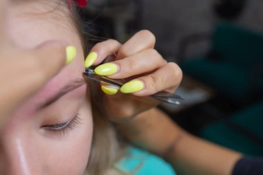 Güzellik uzmanı, kaplıca merkezinde balmumundan yapılmış kaş kaşlarıyla tüy döküyor. Çekici kadın güzellik salonunda yüz bakımı yaptırıyor..