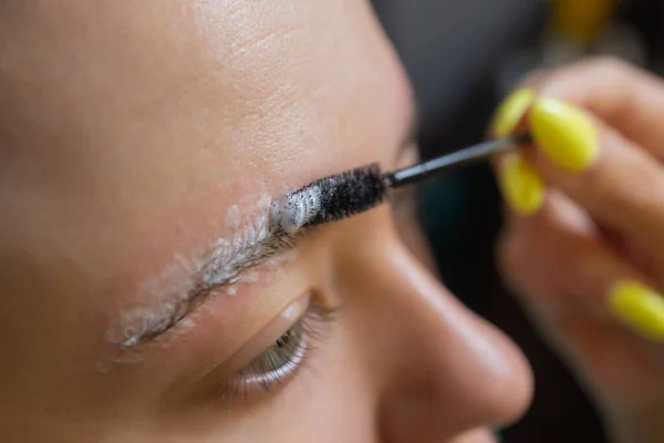 Esthéticienne faisant épilation avec bande de cire les sourcils des jeunes femmes dans le centre de spa. Attrayant femme obtenir des soins du visage au salon de beauté. — Photo