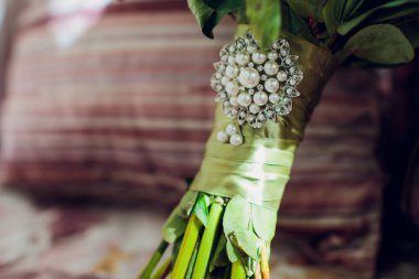 Masanın üzerinde çok güzel bir gelin buketi var. Çiçekli düğün teması.