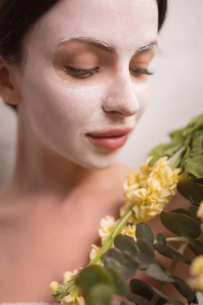 Spa Vrouw aanbrengen van Facial clay Mask. Schoonheidsbehandelingen. Close-up portret van mooi meisje met een handdoek op haar hoofd aanbrengen gezichtsmasker. — Stockfoto