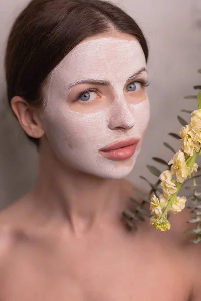 Spa Woman applying Facial clay Mask. Beauty Treatments. Close-up portrait of beautiful girl with a towel on her head applying facial mask. — Stock Photo, Image