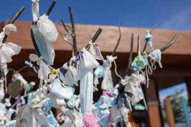 Birçok tıbbi maske sokaktaki demir bir çite bağlıdır..