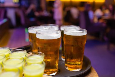 Bir şişe votka, shot bardakları ve limon dilimleri. Karanlık taş arka planda.