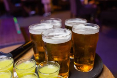 Bir şişe votka, shot bardakları ve limon dilimleri. Karanlık taş arka planda.