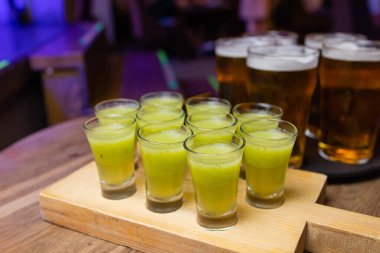 Bir şişe votka, shot bardakları ve limon dilimleri. Karanlık taş arka planda.