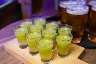 Bir şişe votka, shot bardakları ve limon dilimleri. Karanlık taş arka planda.