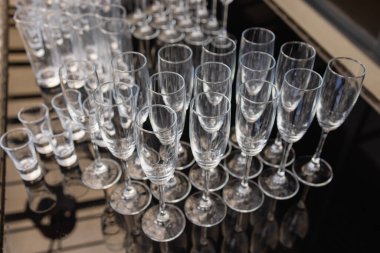 Restoranda bir grup boş ve şeffaf şampanya kadehi. Barmen tarafından şampanya için hazırlanmış temiz bardaklar..