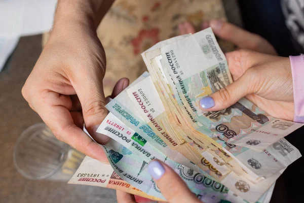 Rublos rusos en la mano de un fan.male mano sosteniendo muchos de los billetes rusos.La transferencia de dinero.El aislado cinco milésimas de rublos rusos denominaciones en una mano. — Foto de Stock