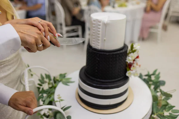 Hands of bride and groom cut of a slice of a wedding cake. — Stock Photo, Image