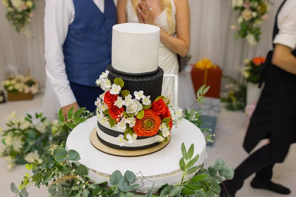 Hands of bride and groom cut of a slice of a wedding cake. — Stock Photo, Image