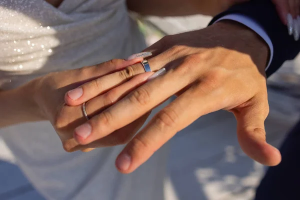 Mão homem colocando um anel de casamento no dedo noivas. — Fotografia de Stock