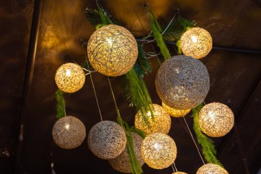 Beyaz ışık topları. Her birinin içinde lamba bulunan toplarla yapılmış modern sanat lüks avizesi gümüş bacaklı güzel bir çiçeğe işaret ediyor. Arka planda tavandan sarkan aydınlatma topu