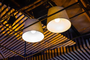 Beyaz ışık topları. Her birinin içinde lamba bulunan toplarla yapılmış modern sanat lüks avizesi gümüş bacaklı güzel bir çiçeğe işaret ediyor. Arka planda tavandan sarkan aydınlatma topu